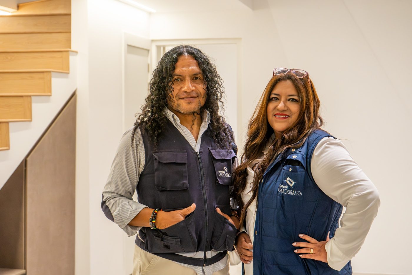 Dos integrantes del equipo de Corporación Cartográfica con el chaleco de la empresa