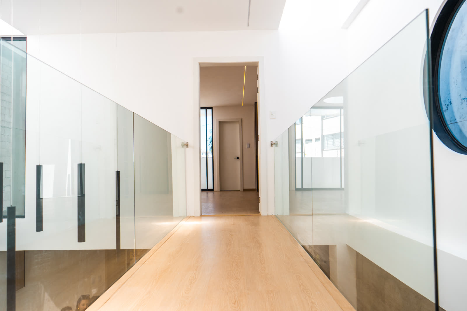 Pasillo del segundo piso con barandas de vidrio